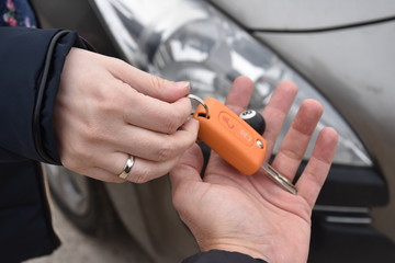 car sales. one person sells car and gives the key to the new owner - Image