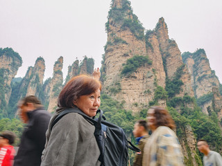 Senior asian women with Beautiful mountain of Yuanjiajie or Avartar mountain and motion blur of people at Zhangjiajie National Forest Park in Wulingyuan District Zhangjiajie City China