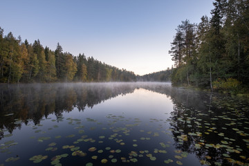 Scenic autumn landscape with calm lake and fall colors at morning in Finland
