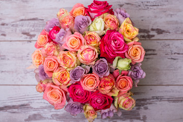 Beautiful bouquet of roses in a gift box. Bouquet of pink roses. Pink roses close-up. on wooden background, with space for text.