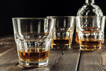 Whiskey glass and bottle on the old wooden table