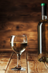Wine bottles with glass, wooden background