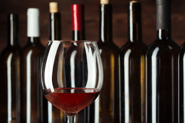 Wine bottles with glass, wooden background