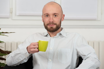young man with a beard drinking cup of coffee