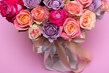 Beautiful bouquet of roses in a gift box. Bouquet of pink roses. Pink roses close-up. on pink background, with space for text.