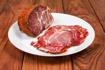 Partly sliced dried pork neck on dish close-up