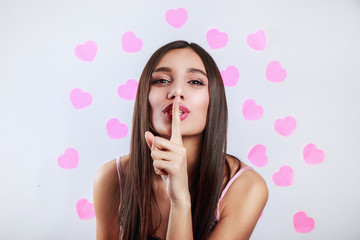 Beautiful girl with bright makeup and long hair telling a secret .Expressive facial expressions. Valentines day love concept