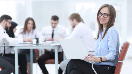 Executive businesswoman with laptop on blurred background business team