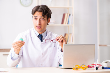 Young handsome doctor oculist working at the clinic