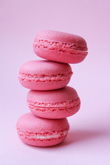 Four pink macaroons on a light pink background, sweet minimal food concept