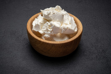 Fototapeta na wymiar Traditional Mascarpone cheese in wooden bowl on concrete background
