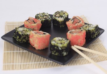 Sushi Set - different types of Maki sushi and chopsticks on a b