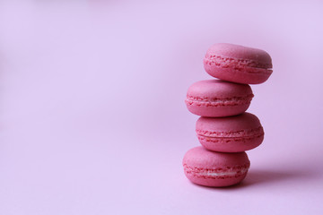 Four pink macaroons on a light pink background, sweet minimal food concept