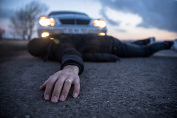 young man lying on road