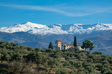 Fototapeta na wymiar View from the city of Granada to mountain Sierra Nevada and a abandoned old house
