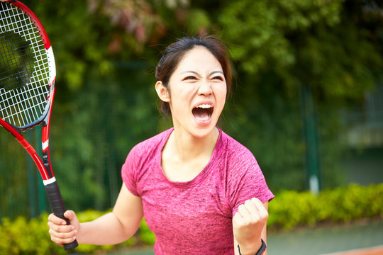 Young Asian Female Tennis Player Celebrating After Scoring