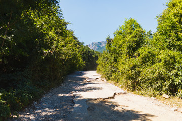bad broken road to the mountains. Serpentine to the mountains