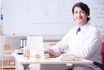 Young handsome dentist in front of the whiteboard