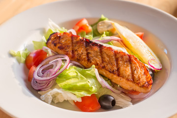 salad with baked salmon. the dish in the cafe