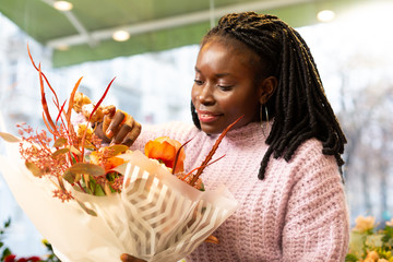 Professional florist standing near flowers in boutique