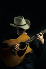 Man playing guitar on black background