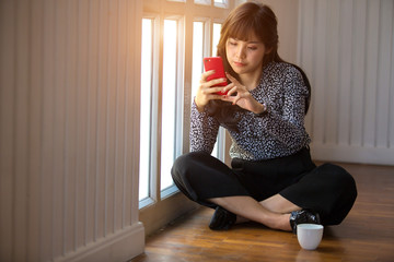 Woman holding phone while relaxing at home