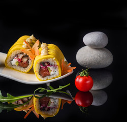 Sushi  rolls on the original plate on black. Art photo.