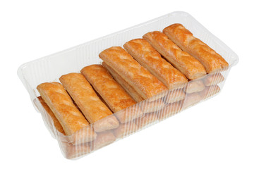 Cookies from strips of puff yeast dough with sugar glaze in plastic box isolated