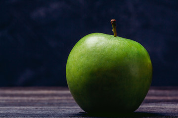 Beautiful ripe green apple close-up on a dark background