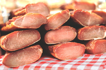 Smoked and handmade meats on red and white table cover