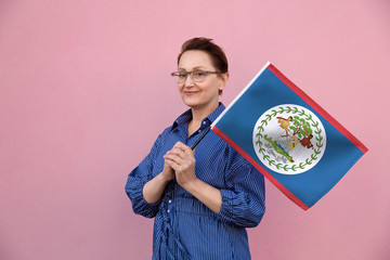 Belize flag. Woman holding Belize flag. Nice portrait of middle aged lady 40 50 years old holding a...