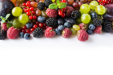 Mix berries on a white background. Ripe red currants, grapes, blackberries, blueberries and raspberries on white background. Top view. Fruits with copy space for text. Black-blue and red food.