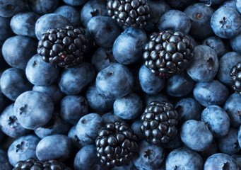 Texture berries close up. Top view. Black and blue berries. Ripe blueberries and blackberries. Various fresh summer berries.