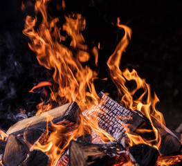 Flaming Logs, fire flames with sparks flying in the air, close-up.