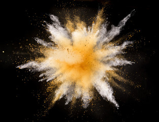 Silver and gold powder explosion on black background. Freeze motion.