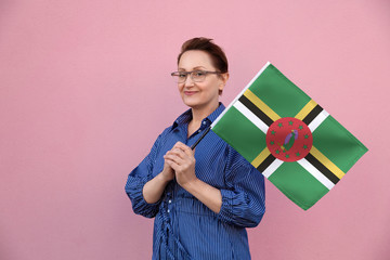 Dominica flag. Woman holding Dominican flag. Nice portrait of middle aged lady 40 50 years old...