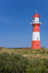 Fototapeta na wymiar Red and white lighthouse in the dunes of Borkum, Germany