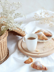 Obraz na płótnie Canvas Breakfast table with a cup of coffee and croissants, light and bright mood
