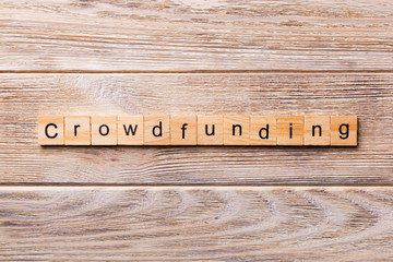 CROWDFUNDING word written on wood block. CROWDFUNDING text on wooden table for your desing, concept