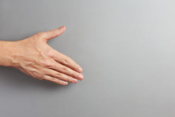 Male hand on gray background with copy space