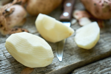 Potato peeling on the rough wooden boards of a country table
