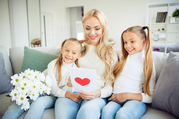 Portrait of nice lovely pretty charming attractive stylish mom pre-teen girls sitting on divan looking giving receiving gifts daydream congrats greetings in light white room