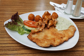 Schnitzel (german cutlet or escalope) with fried chanterelles and potato croquettes                                © Axel Bueckert