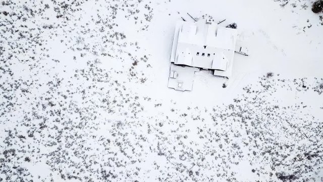 Aerial view of the mountain house covered in snow in the Winter.
