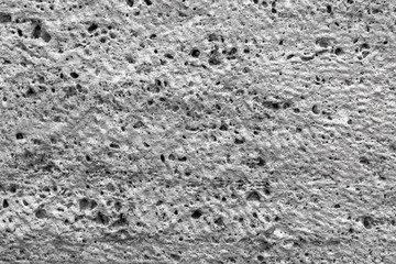 Obraz premium Textured uneven stone surface. Gray limestone. The surface is formed by sawing blocks. Background image. Construction material.