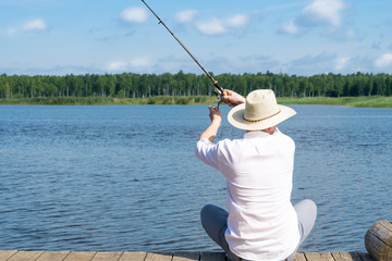 fisherman sitting on the bridge catches fish, active recreation