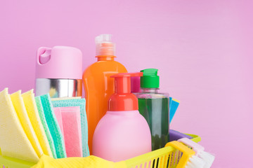 set of liquid cleaning products and items for cleaning indoors on a pink background close-up