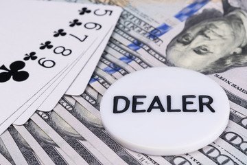 The winning combination of cards in poker and the dealer's chip are on the background of hundred dollar bills