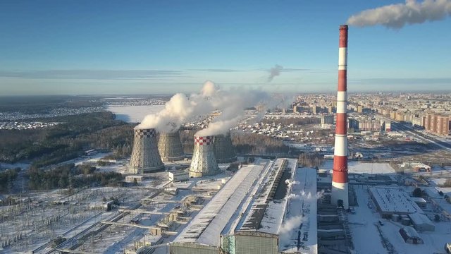 bird eye view heating station covered with snow and cooling towers near town on nice cold day