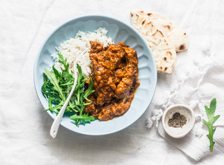 Pork ribs curry with rice, arugula and tortillas on light background, top view. Delicious Indian style lunch
